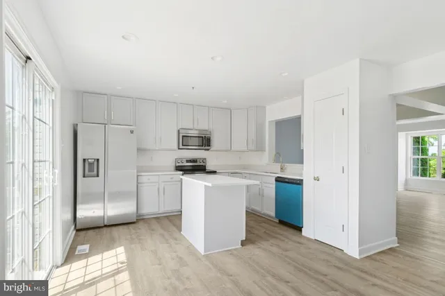 a kitchen with stainless steel appliances a refrigerator stove microwave and sink