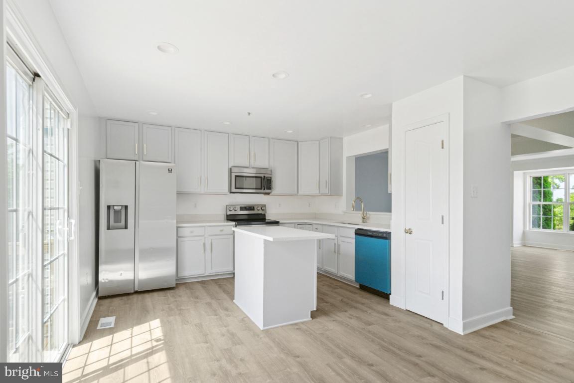 1109 Pomelo Court, Unit 1109 Baltimore, MD 21228 - Photo 8 of 40 a kitchen with stainless steel appliances a refrigerator stove microwave and sink