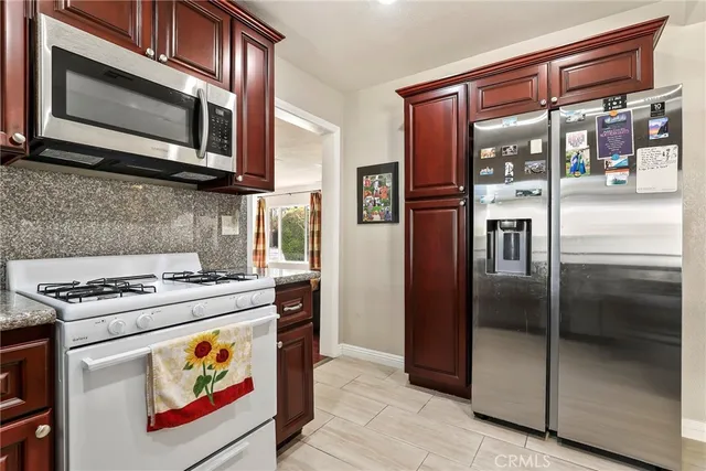 a kitchen with stainless steel appliances granite countertop a stove microwave and refrigerator