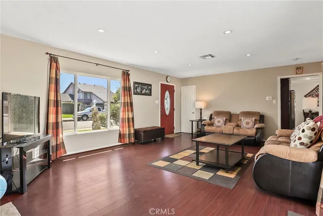 a living room with furniture and a flat screen tv with wooden floor