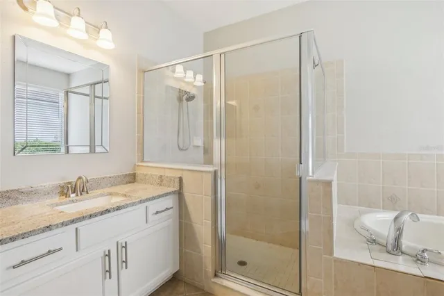 a bathroom with a granite countertop sink a mirror and shower