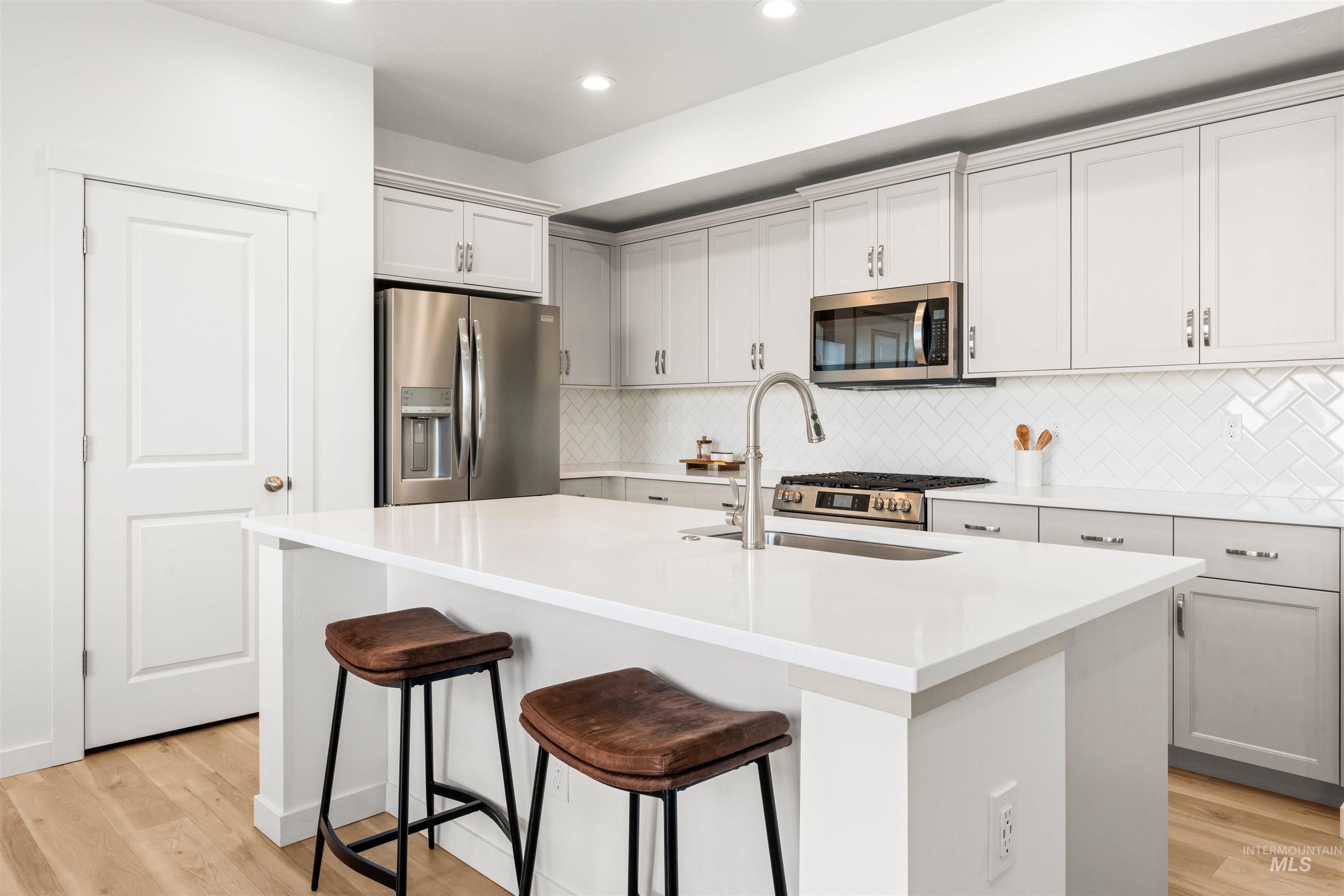 2040 West Gelding Street Middleton, ID 83644 - Photo 13 of 22 Kitchen featuring a breakfast bar, stainless steel appliances, light wood-type flooring, an island with sink, and recessed lighting