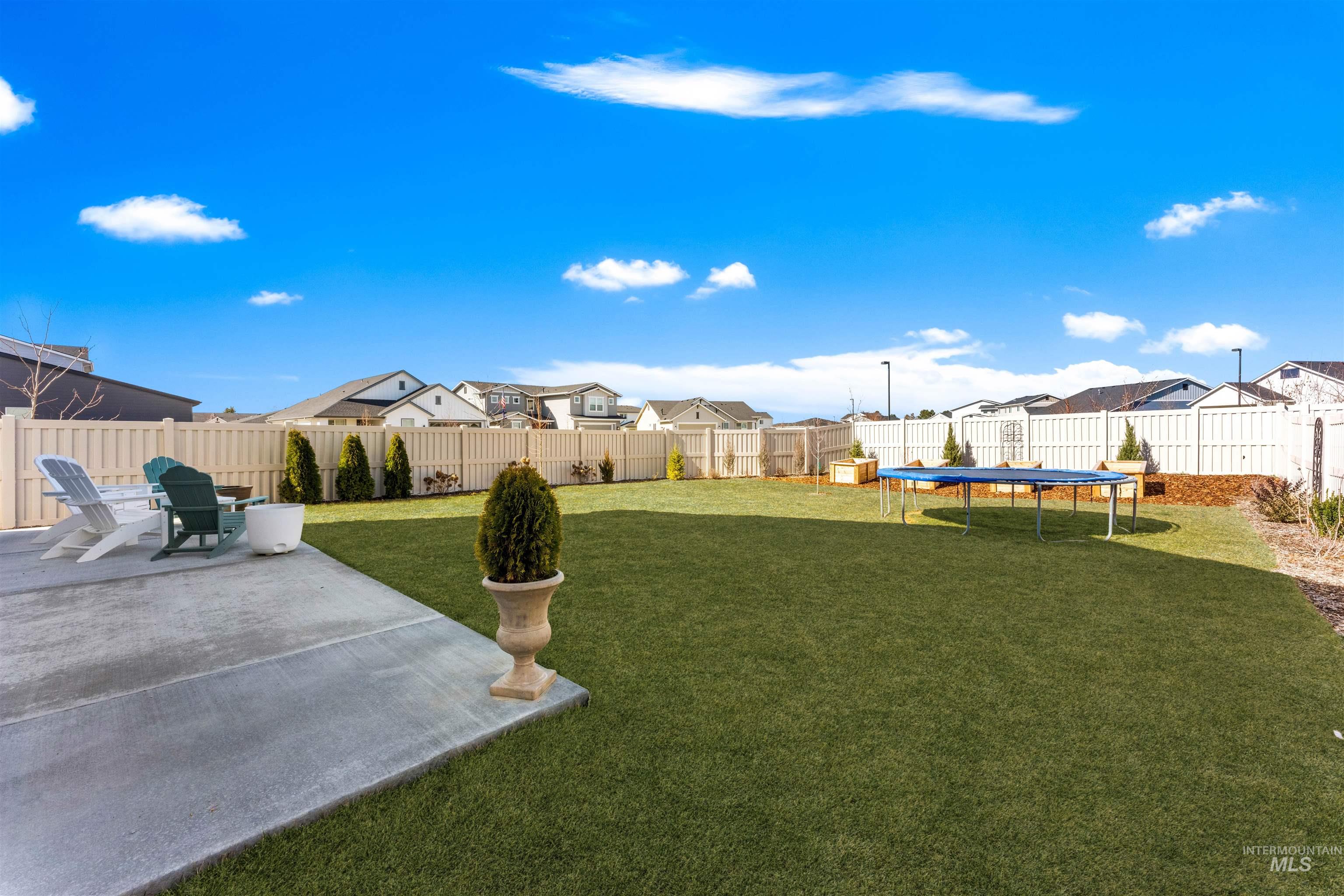 2040 West Gelding Street Middleton, ID 83644 - Photo 4 of 22 Fenced backyard featuring a residential view, a trampoline, and a patio