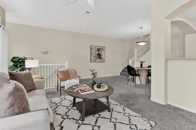 a living room with furniture a rug and white walls