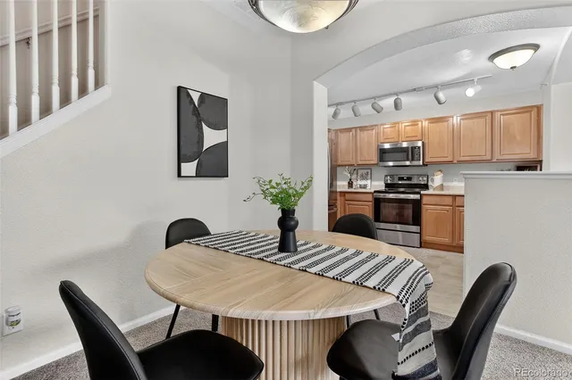 a kitchen with a dining table chairs and a refrigerator