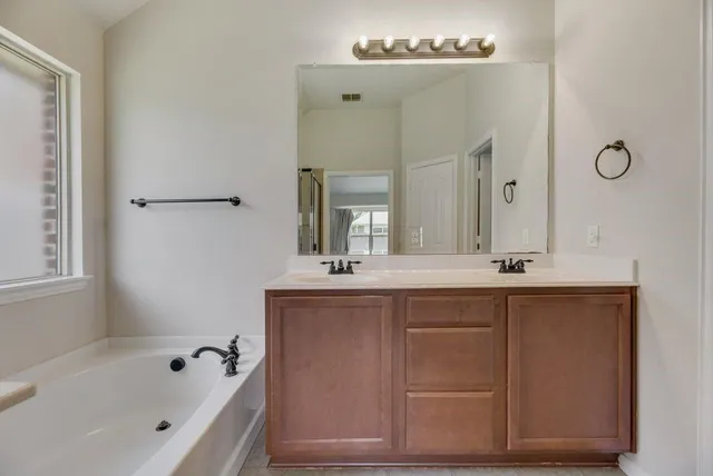 a bathroom with a tub sink and mirror