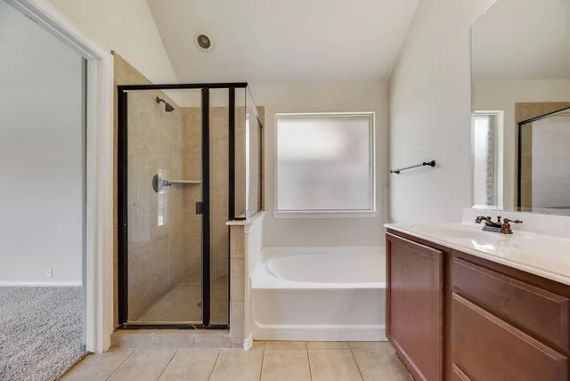 a bathroom with a double vanity sink a mirror and a bathtub