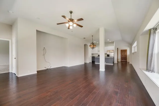 a view of a livingroom with wooden floor and ceiling fan