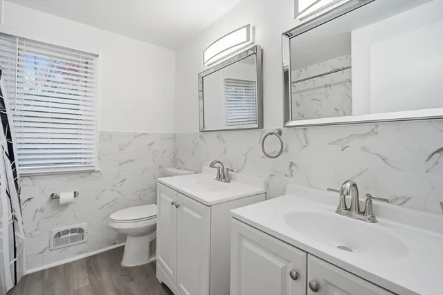 a bathroom with a toilet sink and mirror