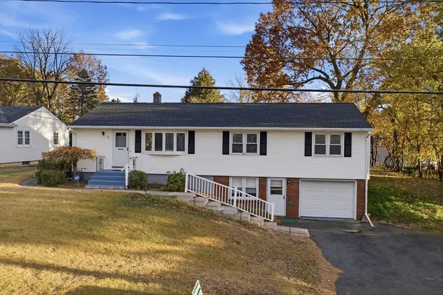 a front view of a house with a yard outdoor seating and garage