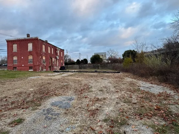 a view of a house with a yard and wooden fence