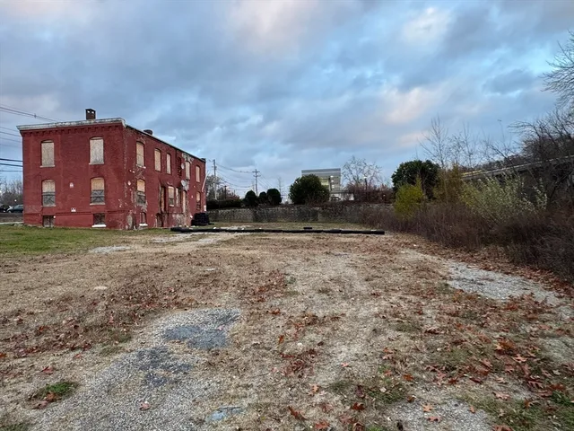 a view of a house with a yard and wooden fence