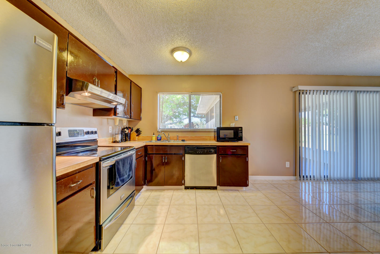 1300 Cromey Road Northeast Palm Bay, FL 32905 - Photo 12 of 29 a large kitchen with stainless steel appliances granite countertop a stove a sink and a refrigerator