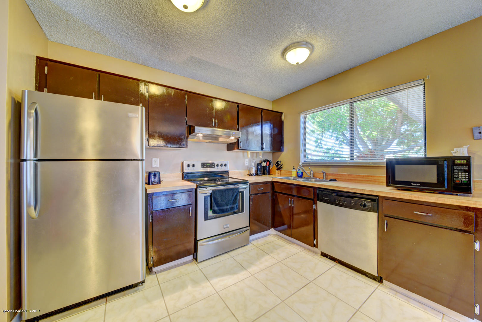 1300 Cromey Road Northeast Palm Bay, FL 32905 - Photo 13 of 29 a kitchen with stainless steel appliances granite countertop a refrigerator sink and cabinets