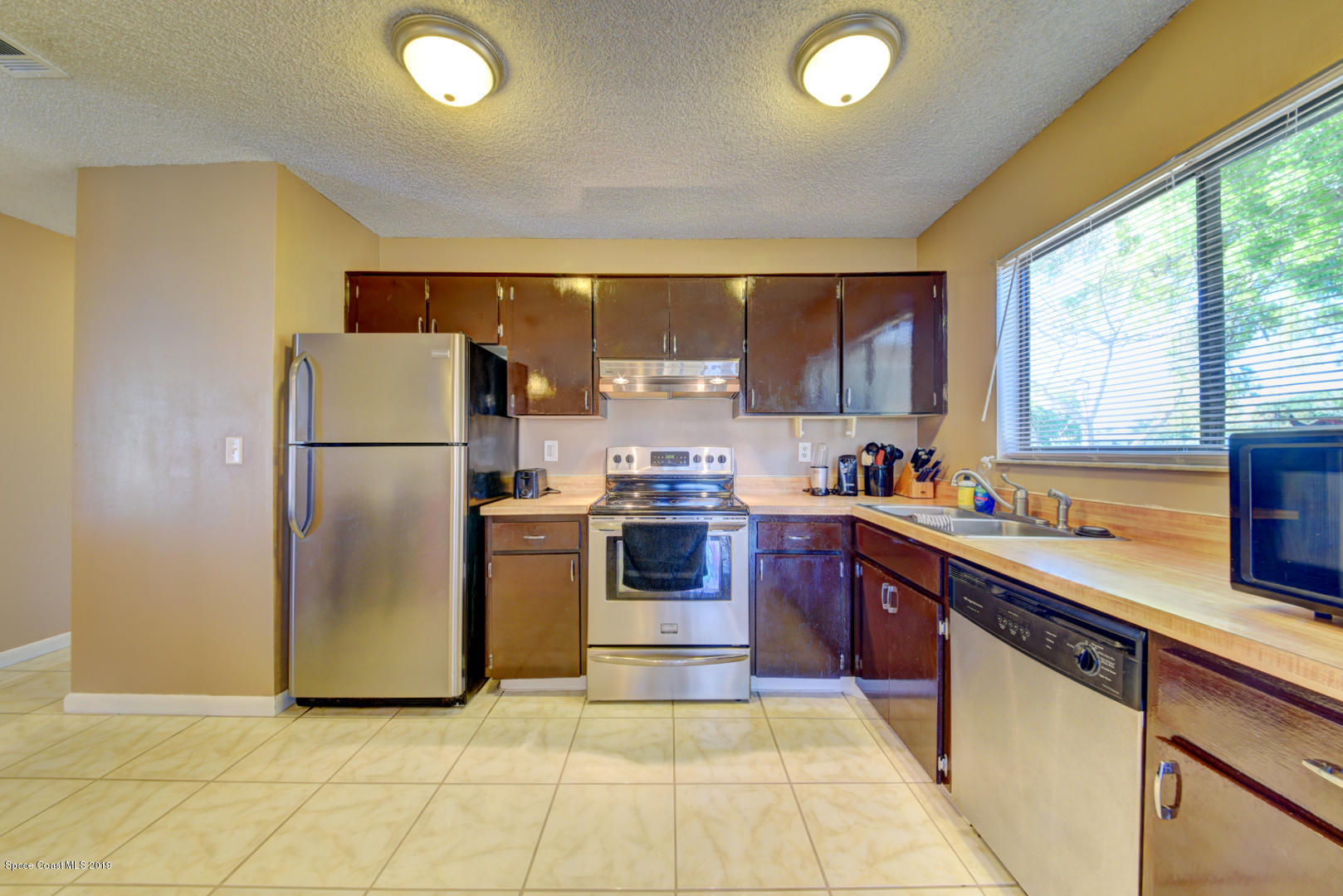 1300 Cromey Road Northeast Palm Bay, FL 32905 - Photo 14 of 29 a kitchen with a refrigerator sink and cabinets