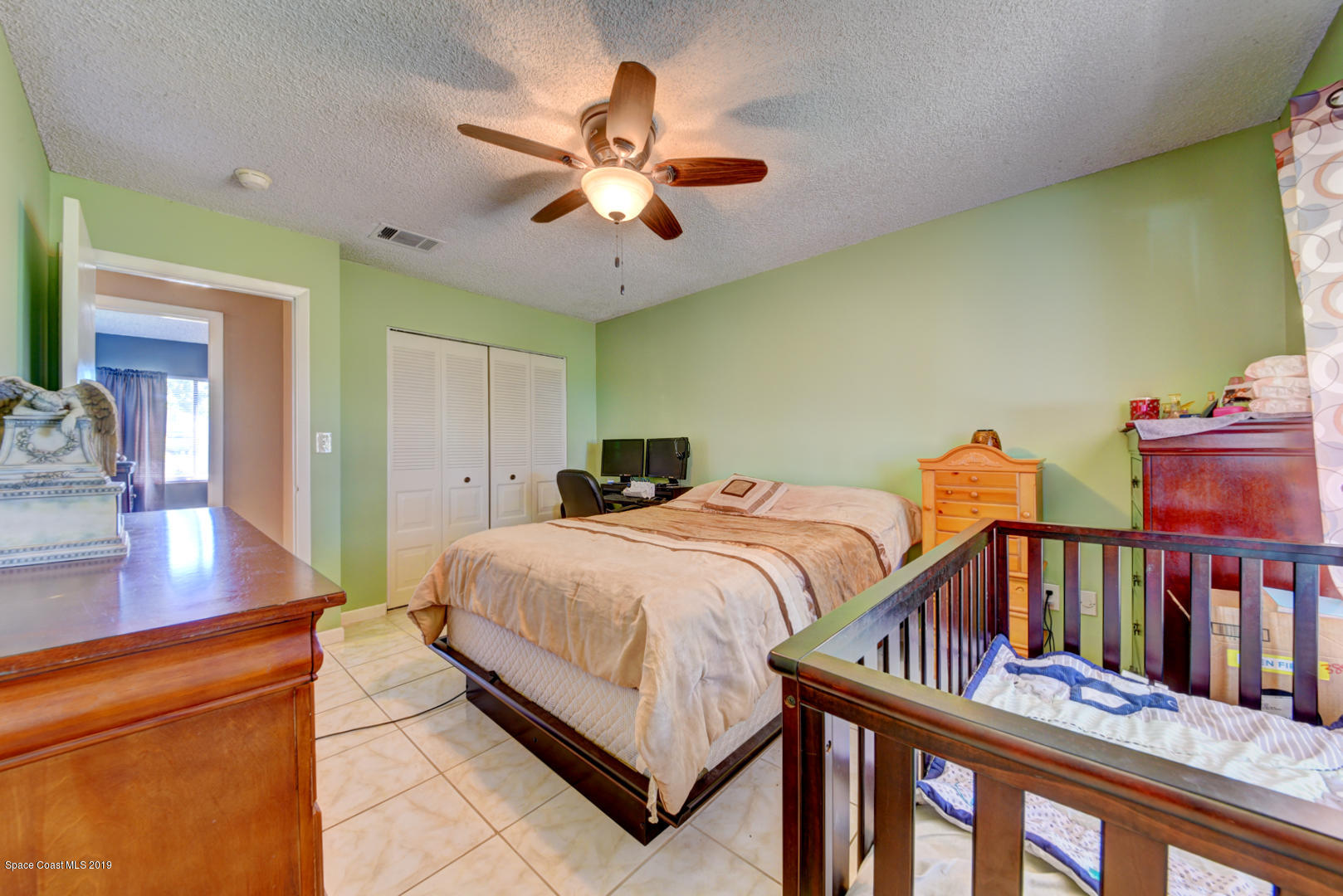 1300 Cromey Road Northeast Palm Bay, FL 32905 - Photo 18 of 29 a bedroom with bed and a chandelier