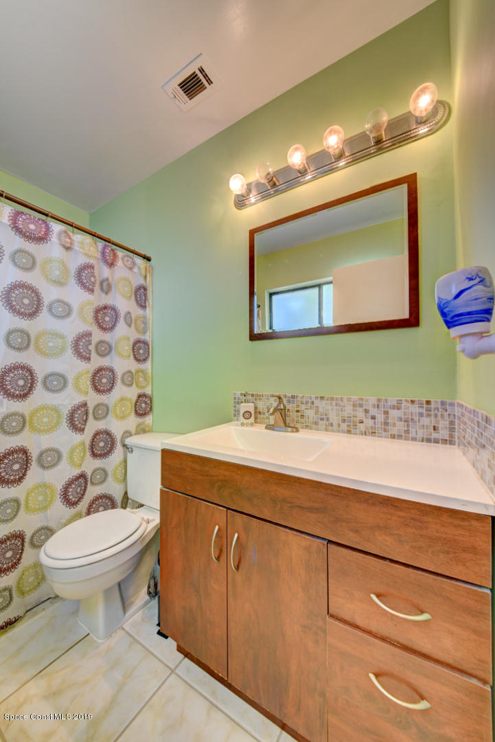 1300 Cromey Road Northeast Palm Bay, FL 32905 - Photo 19 of 29 a bathroom with a sink a toilet and mirror