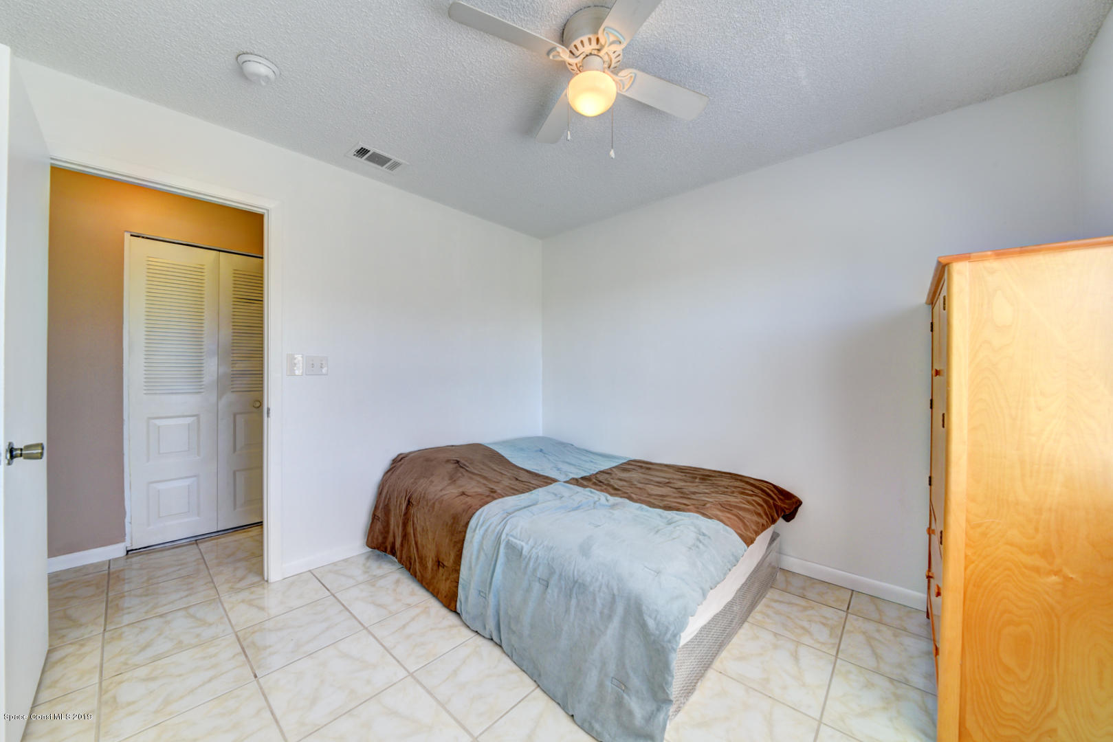 1300 Cromey Road Northeast Palm Bay, FL 32905 - Photo 21 of 29 a bedroom with a bed and a chandelier