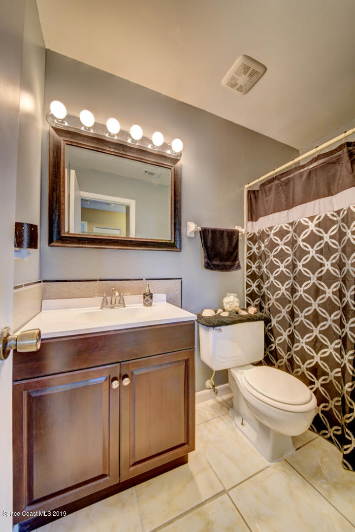 1300 Cromey Road Northeast Palm Bay, FL 32905 - Photo 22 of 29 a bathroom with a sink a toilet a mirror and shower
