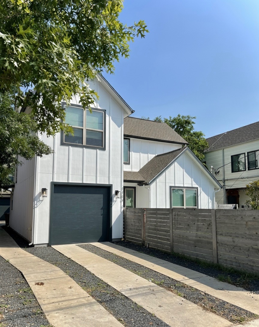 View of front of home featuring a garage and a shingled roof