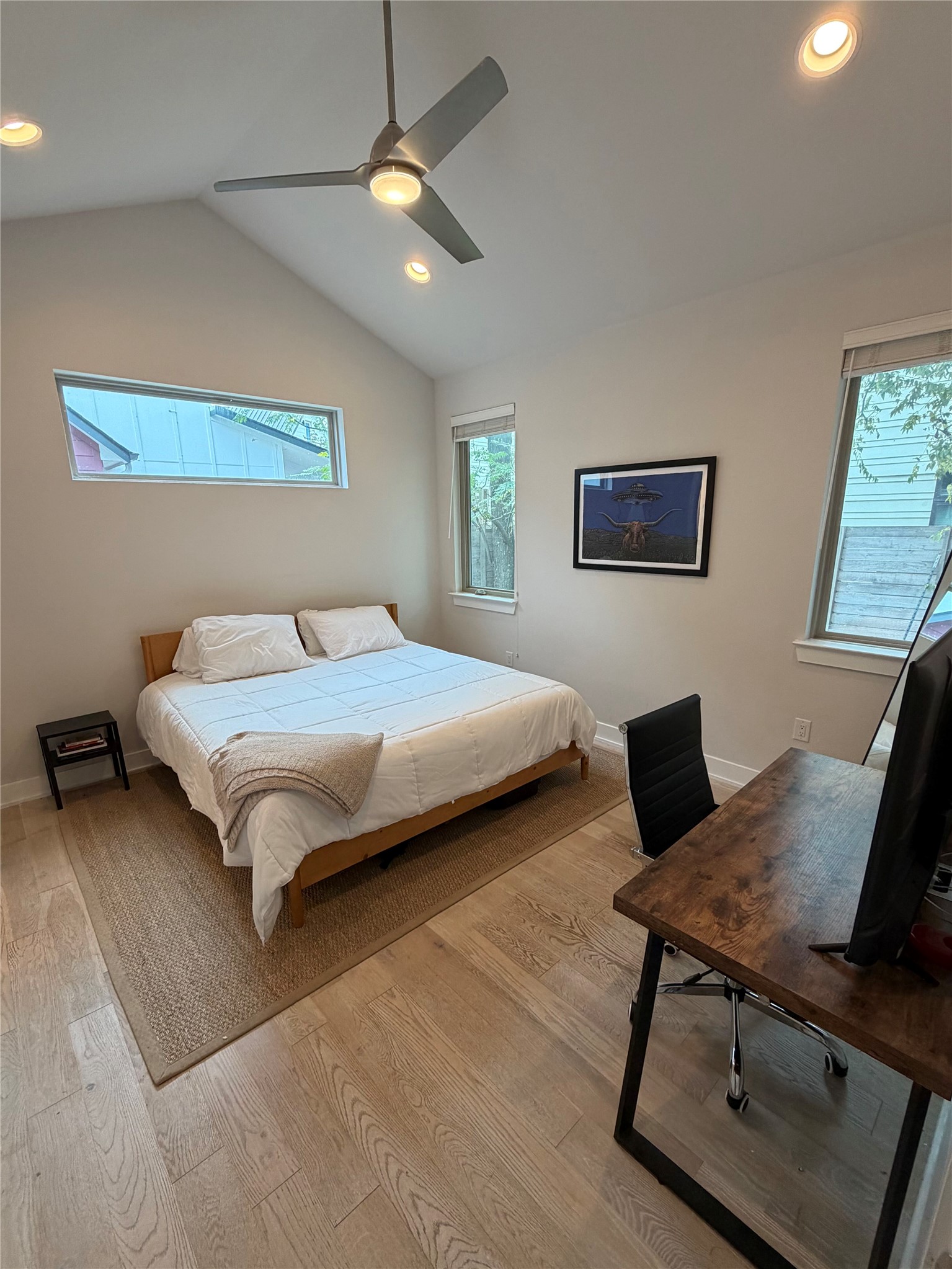 1159 Webberville Road, Unit A Austin, TX 78721 - Photo 14 of 26 Bedroom featuring vaulted ceiling, recessed lighting, a ceiling fan, light wood-style floors, and a desk