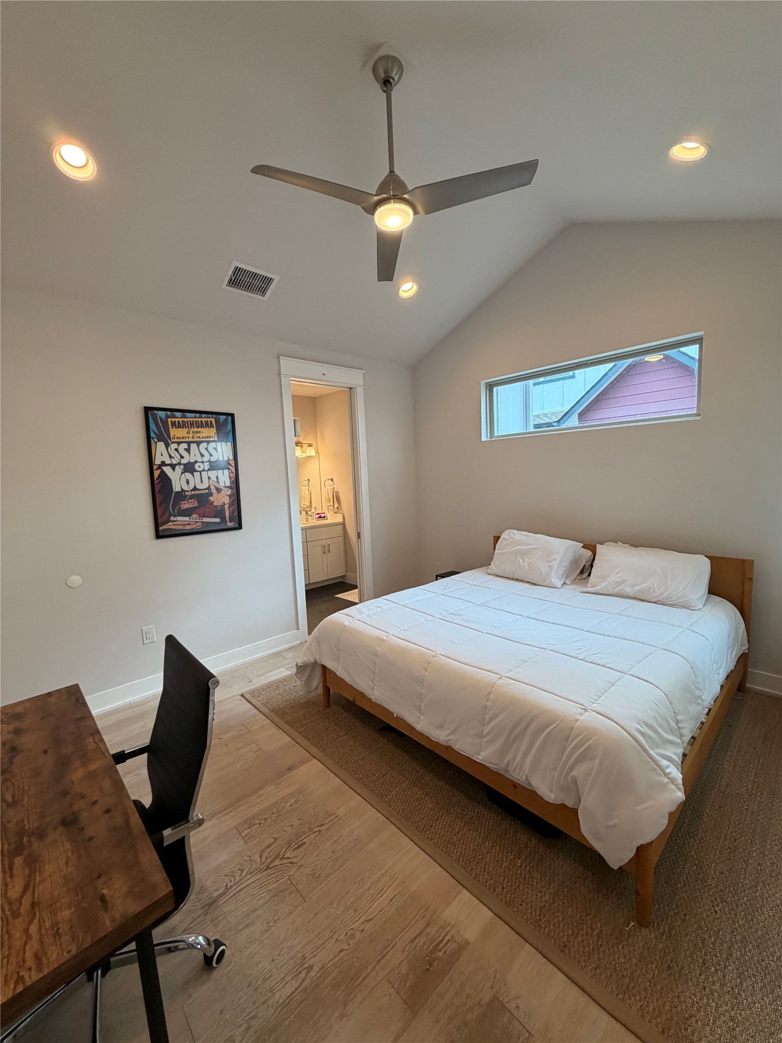 1159 Webberville Road, Unit A Austin, TX 78721 - Photo 15 of 26 Bedroom with a ceiling fan, recessed lighting, a desk, connected bathroom, and wood finished floors