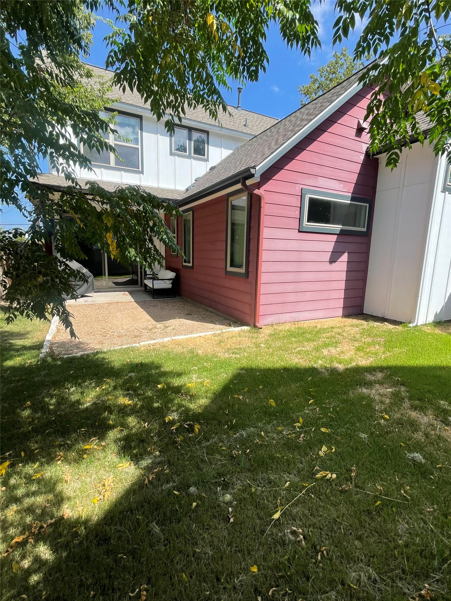 1159 Webberville Road, Unit A Austin, TX 78721 - Photo 26 of 26 Back of property featuring a lawn, roof with shingles, and a patio area