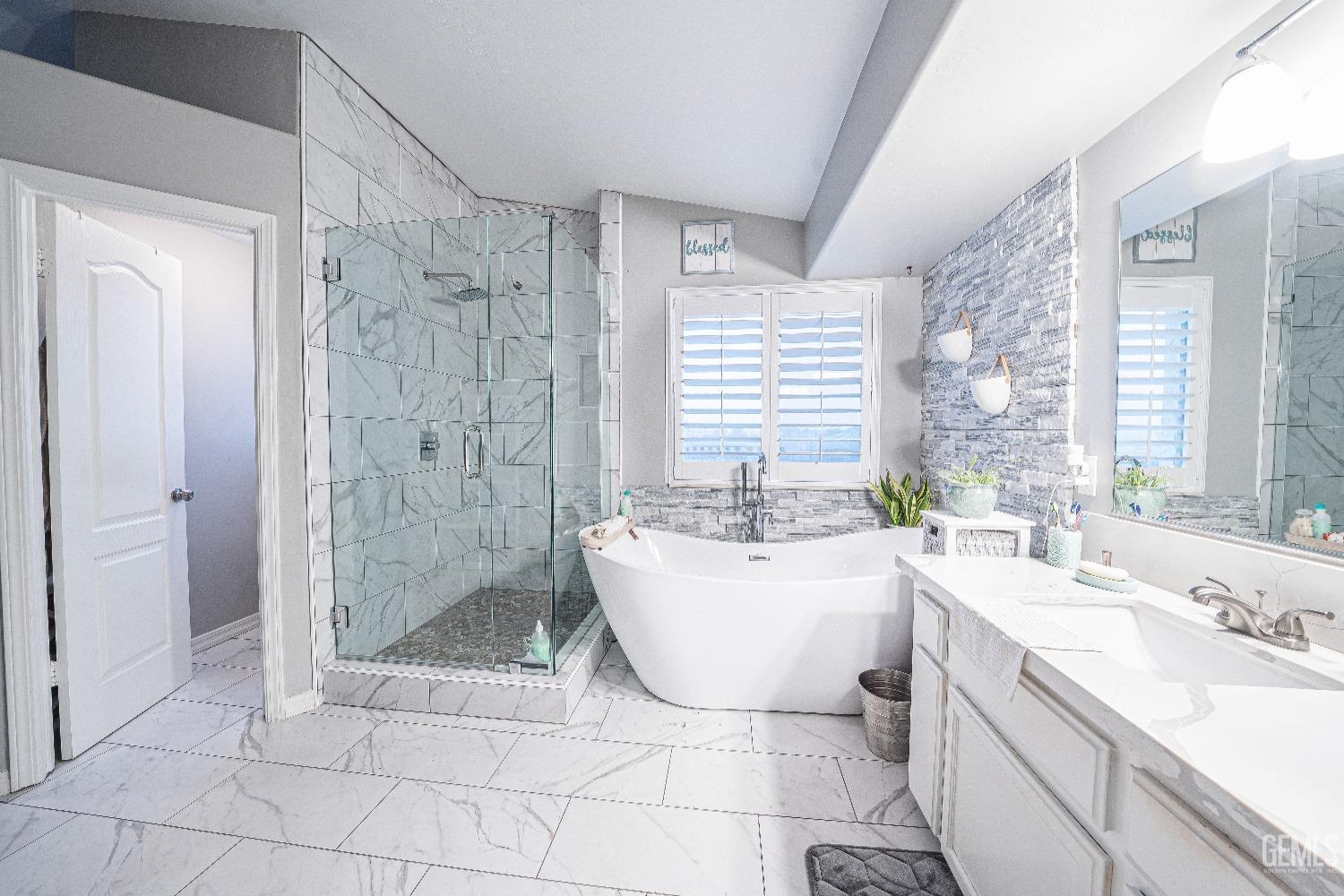 Undisclosed Address Bakersfield, CA 93312 - Photo 20 of 29 a spacious bathroom with a shower a sink a mirror a bathtub and shower