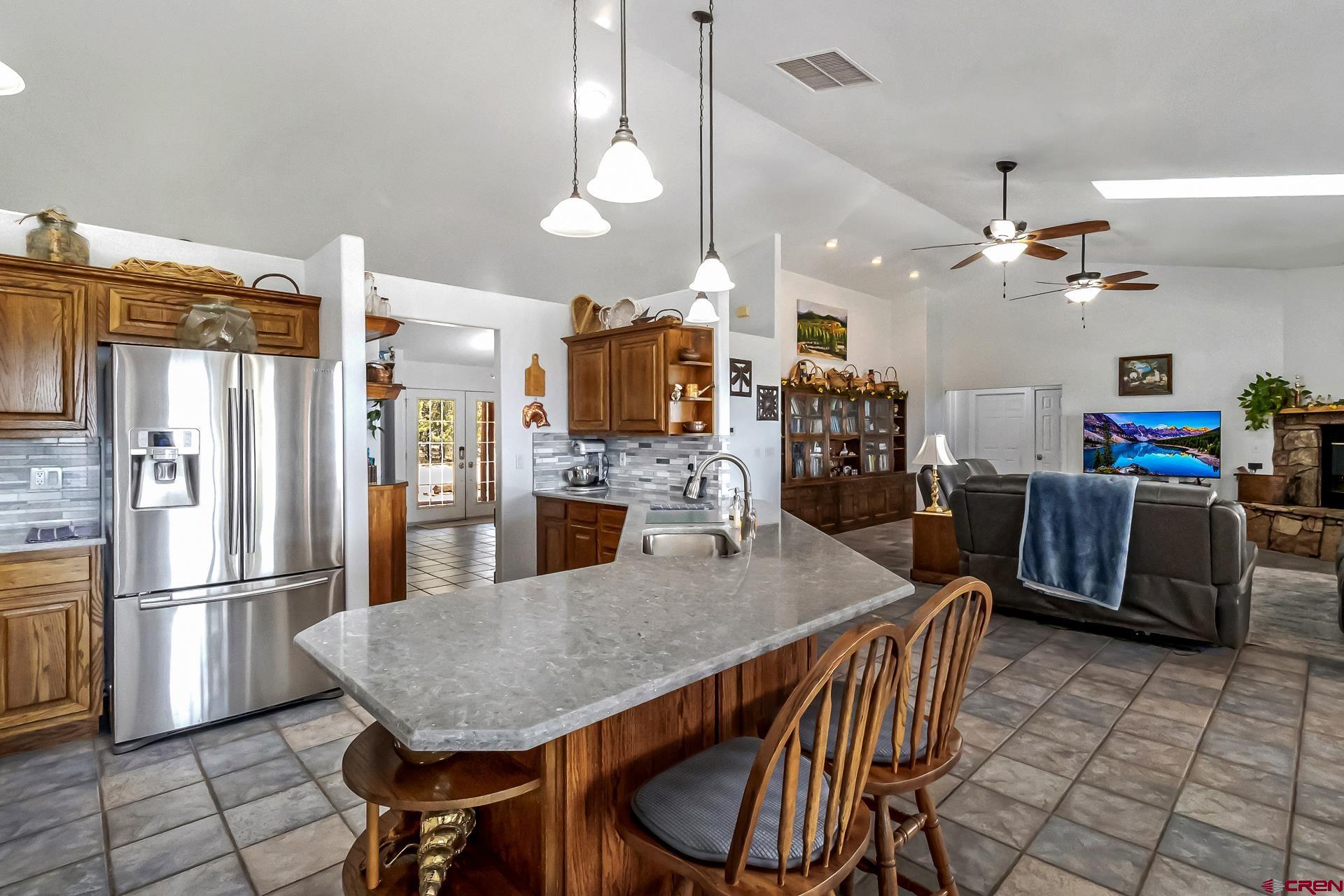 17656 2550th Road Cedaredge, CO 81413 - Photo 13 of 45 a kitchen with stainless steel appliances granite countertop a refrigerator a oven a sink a dining table and chairs with wooden floor