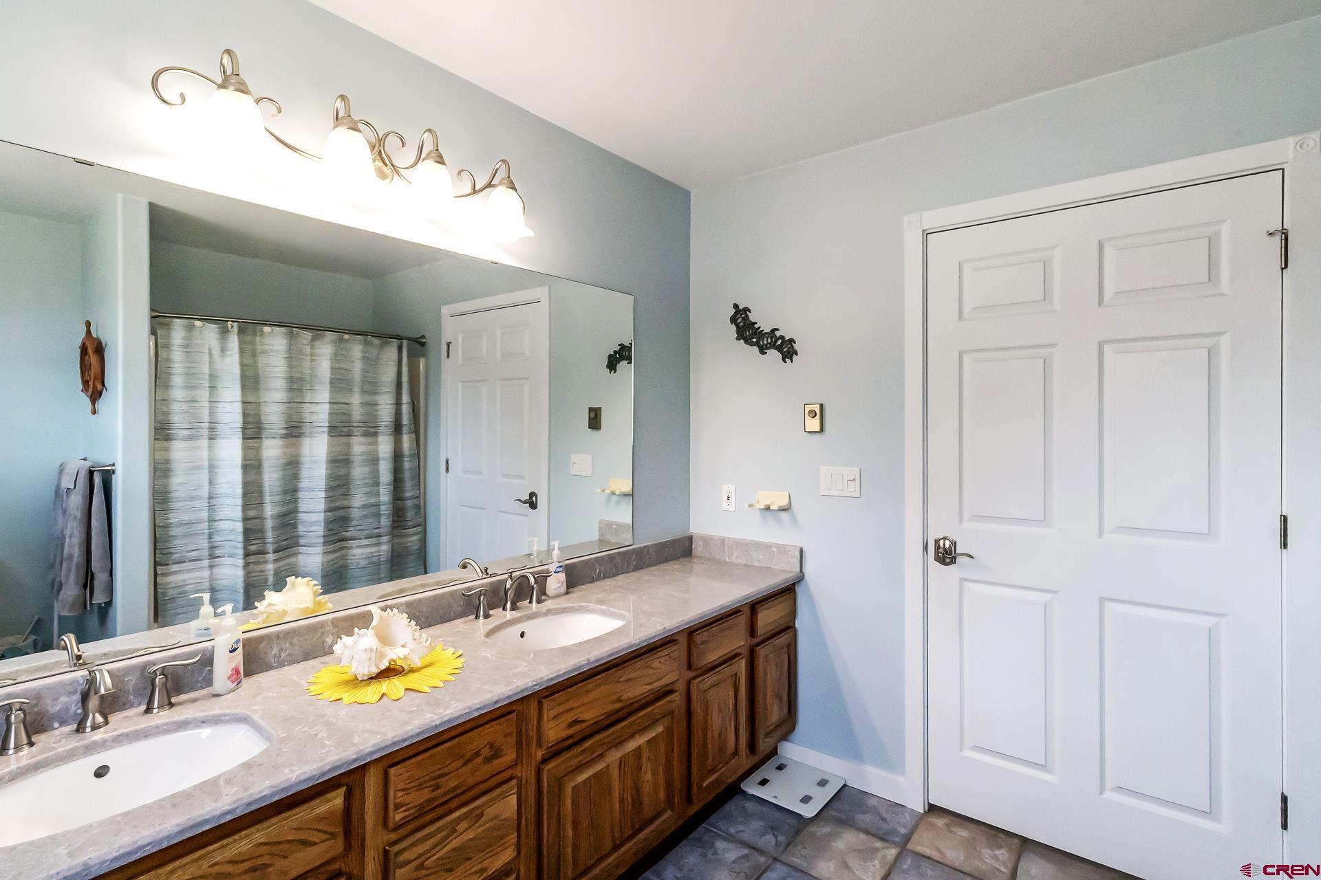 17656 2550th Road Cedaredge, CO 81413 - Photo 22 of 45 a bathroom with a double vanity sink and a mirror