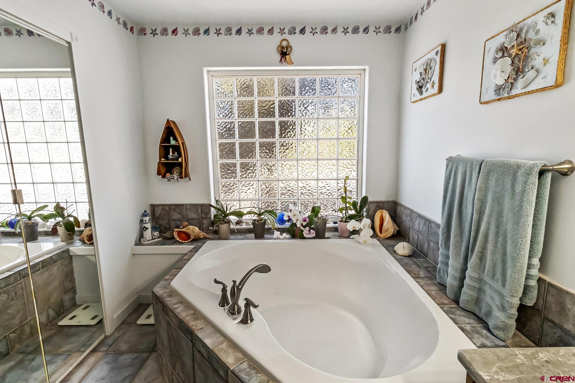 17656 2550th Road Cedaredge, CO 81413 - Photo 28 of 45 a bathroom with a tub a sink and a window