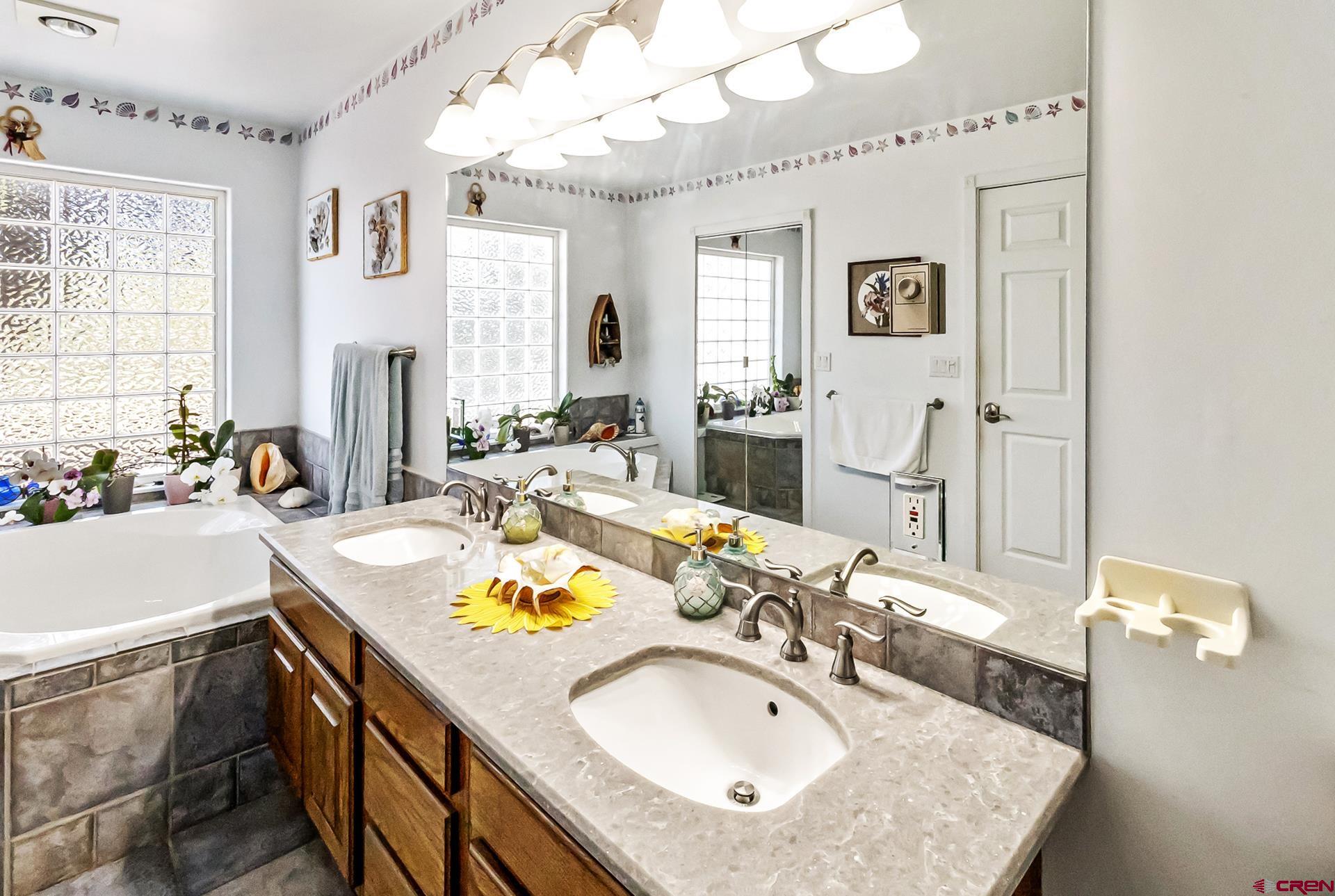17656 2550th Road Cedaredge, CO 81413 - Photo 29 of 45 a bathroom with a sink double vanity granite and a mirror