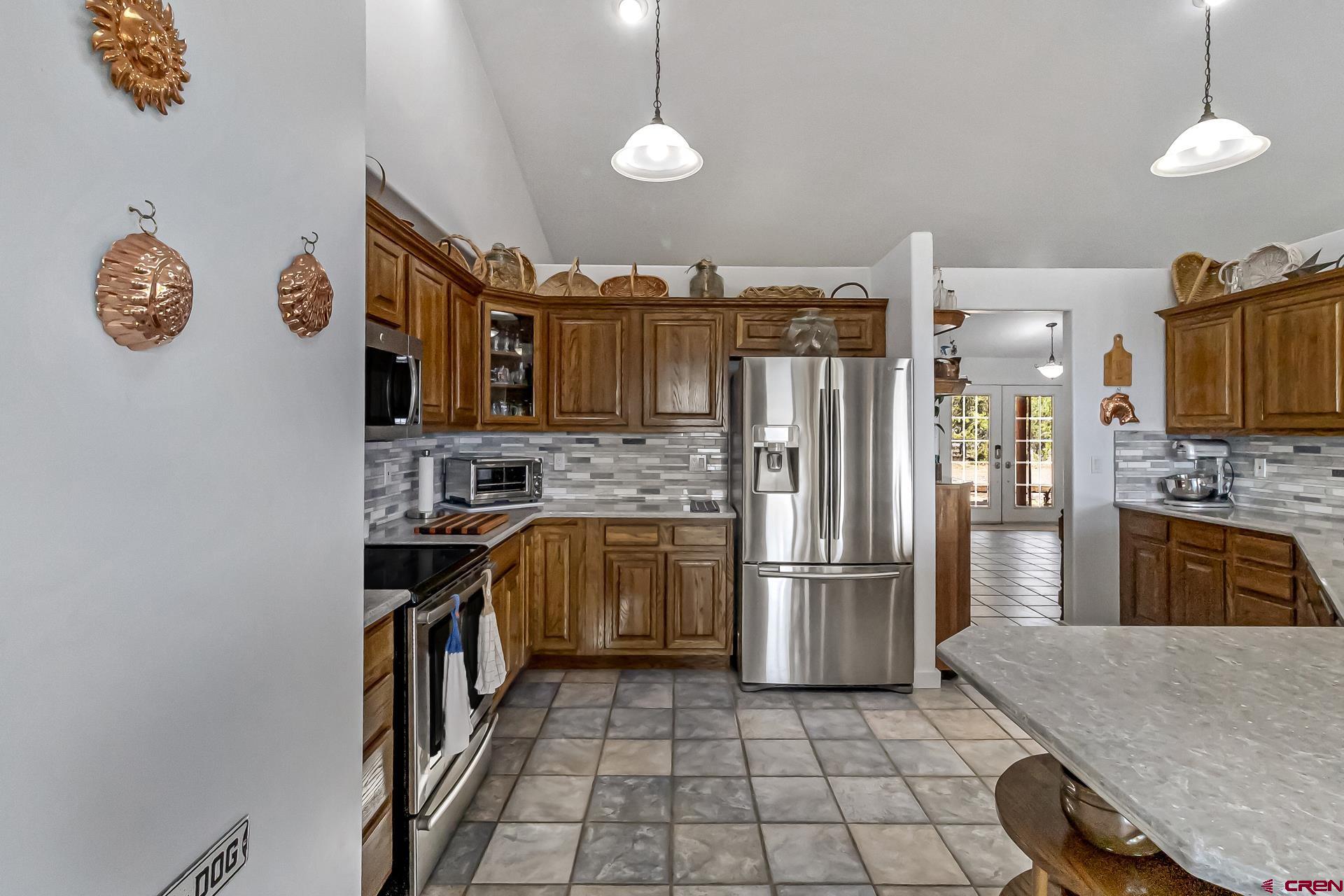 17656 2550th Road Cedaredge, CO 81413 - Photo 9 of 45 a kitchen with stainless steel appliances granite countertop a refrigerator a stove and a sink with cabinets