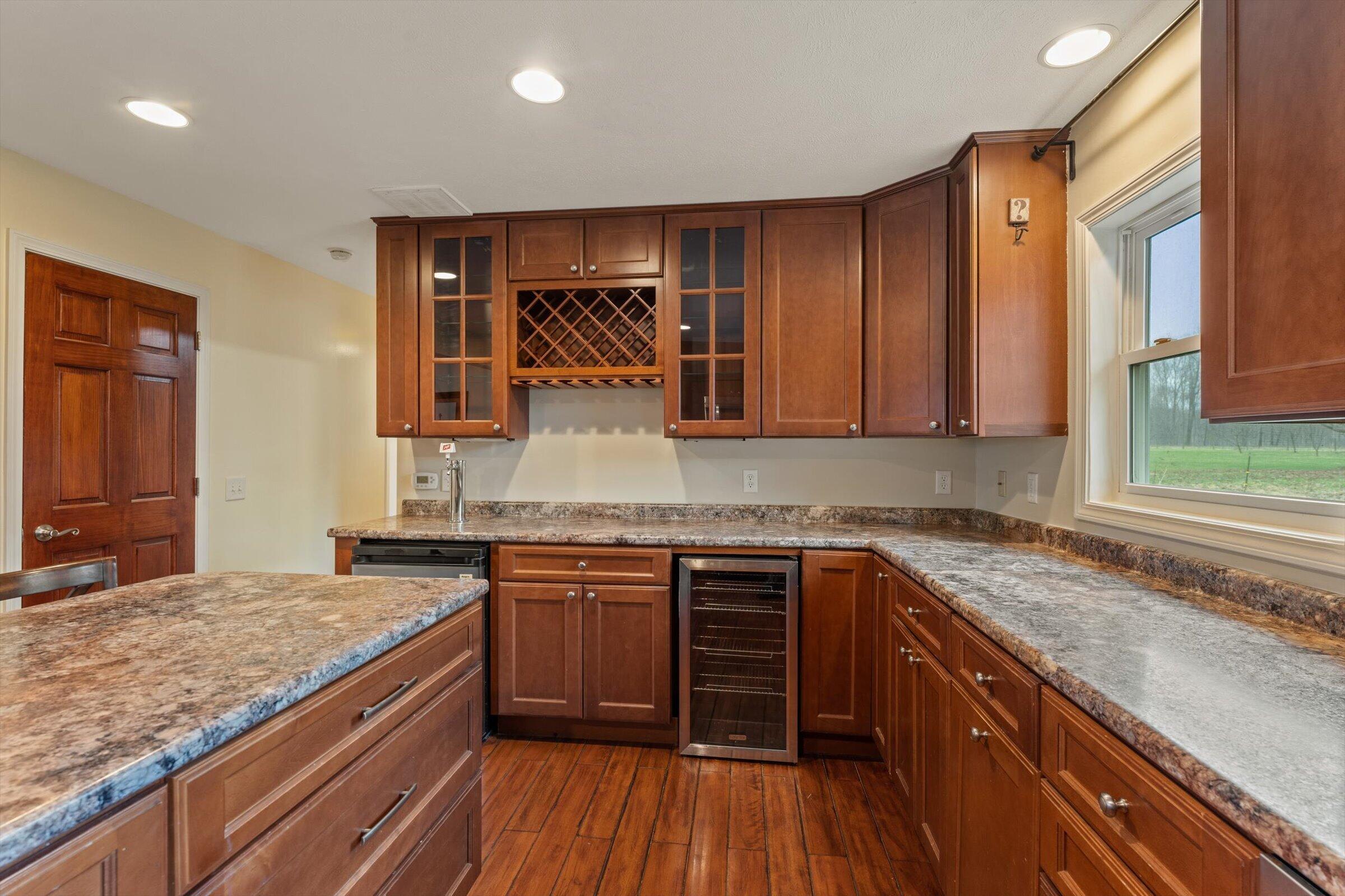 7692 North Emery Road Rolling Prairie, IN 46371 - Photo 16 of 69 a kitchen with stainless steel appliances granite countertop wooden cabinets a sink and dishwasher