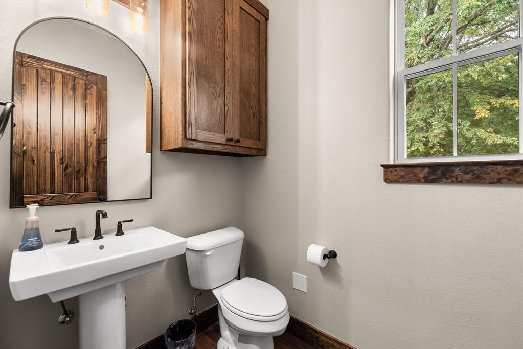 483 Spout Springs Road Pottsboro, TX 75076 - Photo 16 of 35 a bathroom with a sink a toilet and mirror
