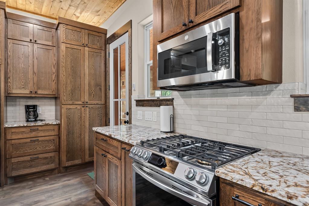483 Spout Springs Road Pottsboro, TX 75076 - Photo 18 of 35 a kitchen with granite countertop a stove and a microwave