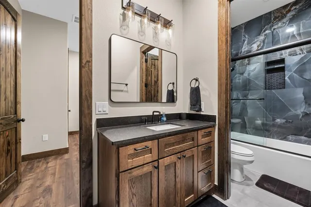a bathroom with a granite countertop sink a toilet and a mirror