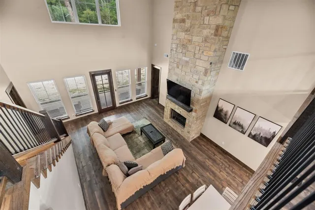 a living room with couches and a fireplace with wooden floor