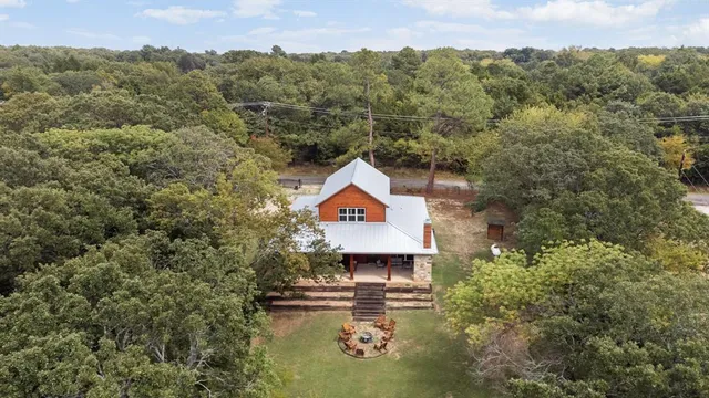 an aerial view of a house with swimming pool and mountains