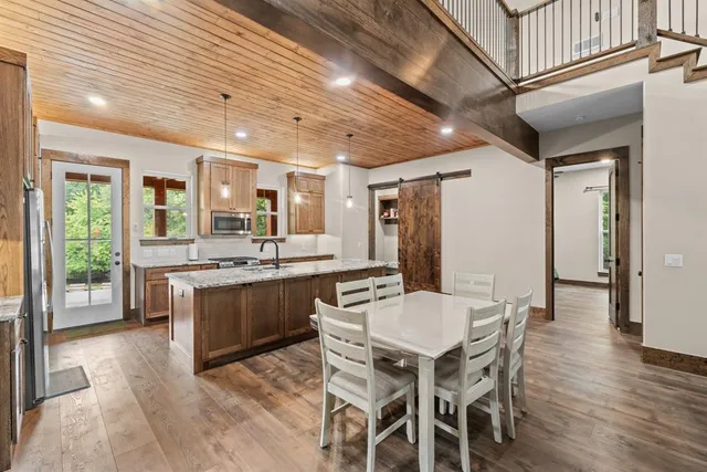 a kitchen with stainless steel appliances granite countertop a kitchen island hardwood floor and a sink