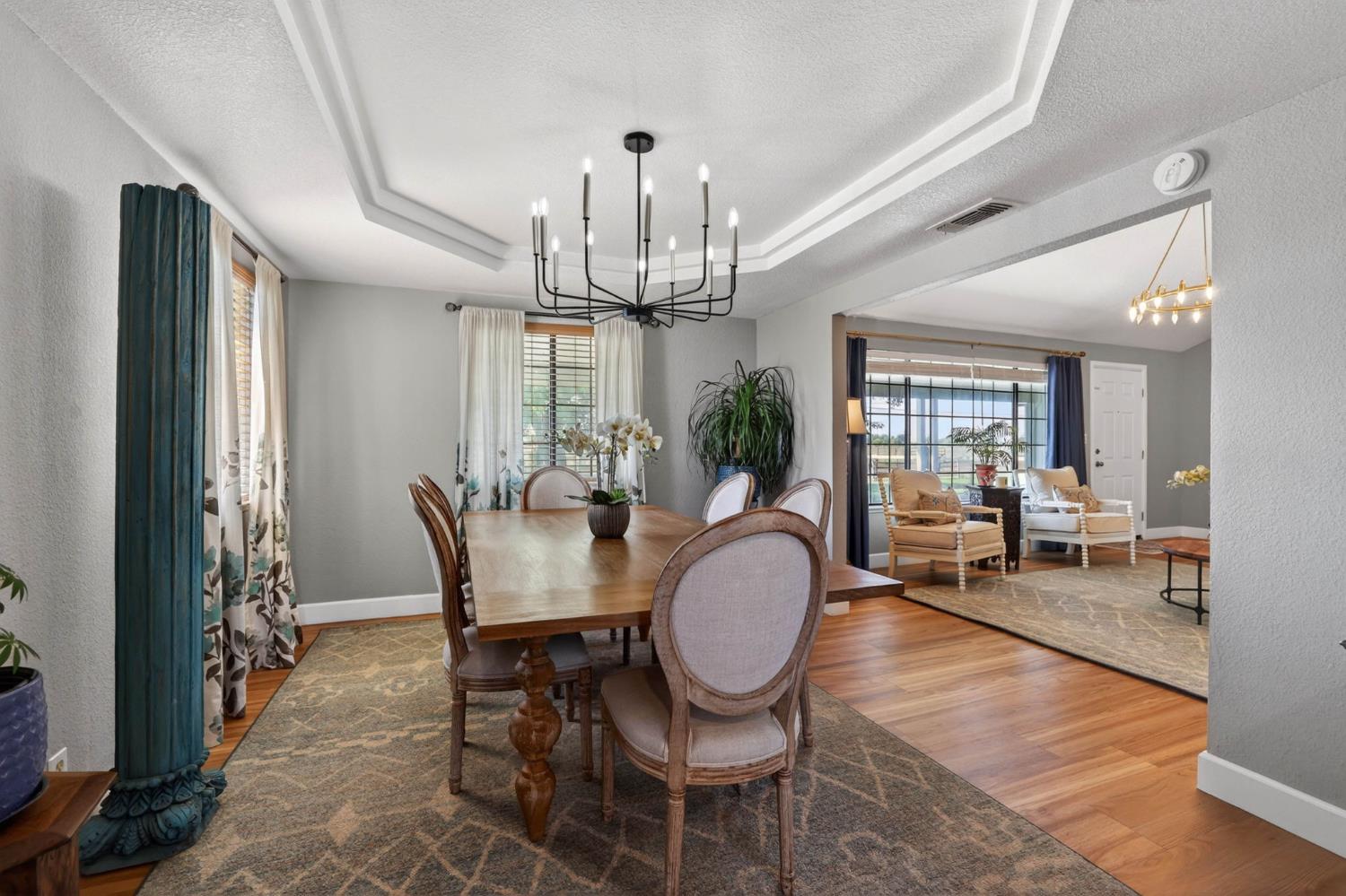 11875 Arno Road Wilton, CA 95693 - Photo 11 of 65 a view of a dining room with furniture a chandelier and wooden floor