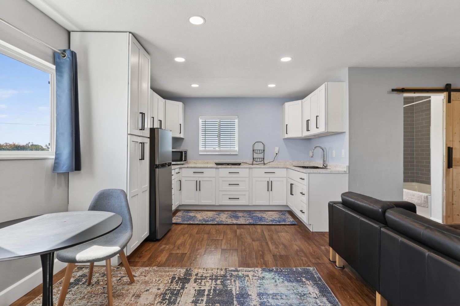 11875 Arno Road Wilton, CA 95693 - Photo 41 of 65 a kitchen with stainless steel appliances a refrigerator a sink dishwasher a stove top oven a dining table and chairs with wooden floor