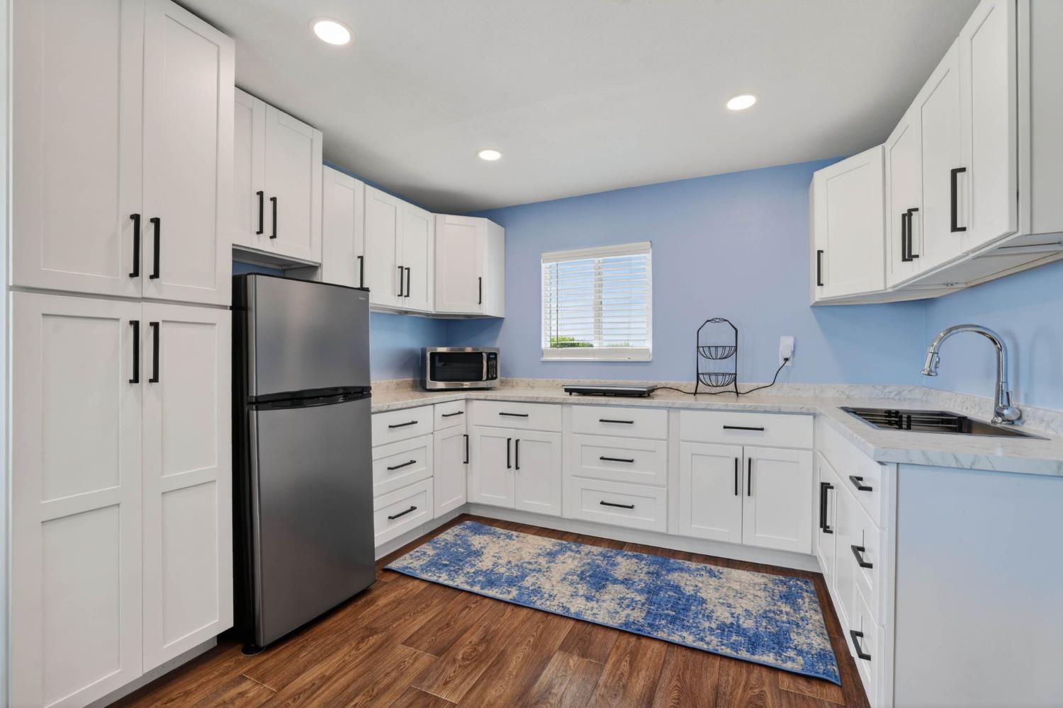 11875 Arno Road Wilton, CA 95693 - Photo 42 of 65 a kitchen with white cabinets and stainless steel appliances