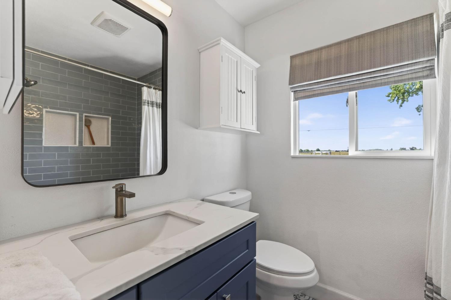 11875 Arno Road Wilton, CA 95693 - Photo 44 of 65 a bathroom with a granite countertop toilet sink and mirror