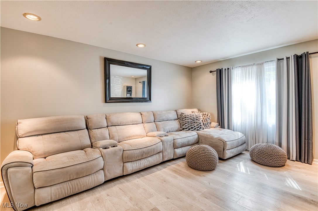 4520 Birchwold Road Cleveland, OH 44121 - Photo 11 of 40 Family room including vinyl plank flooring, reclining sectional, & entertainment system