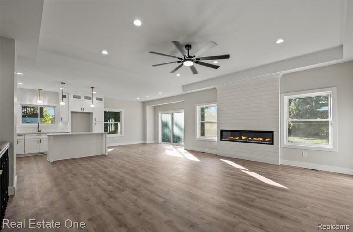 5636 Paris Street Sterling Heights, MI 48310 - Photo 5 of 37 Unfurnished living room with a fireplace, dark wood finished floors, a ceiling fan, and recessed lighting
