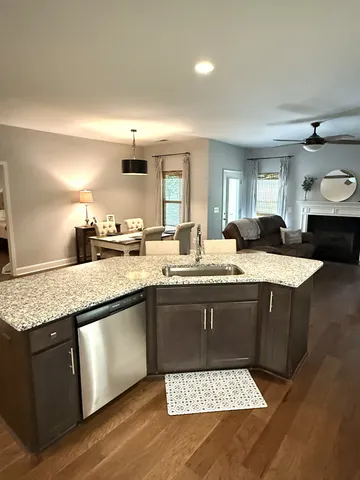 a kitchen with granite countertop stainless steel appliances a sink stove and cabinets
