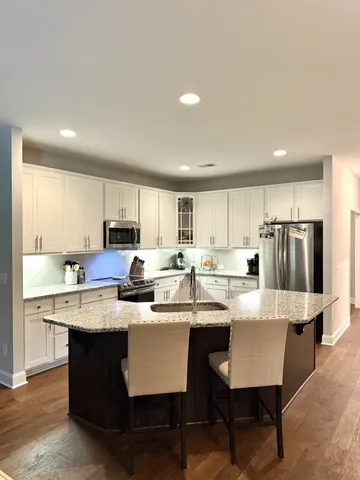 a large kitchen with kitchen island a sink table and chairs