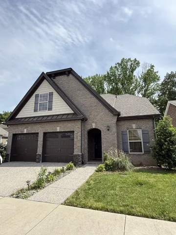 a front view of a house with a garden and yard