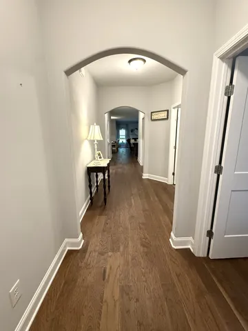 a view of a hallway with wooden floor and furniture